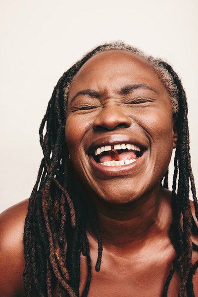 Carefree woman taking a capsule of Omega 3 fatty acids