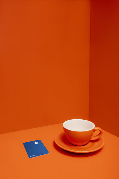 Minimalistic color blocking still life with cup, saucer, and credit card in studio shot