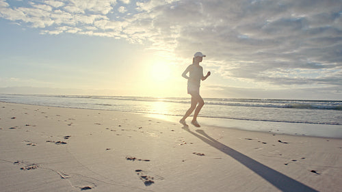 Woman athlete running along the beach