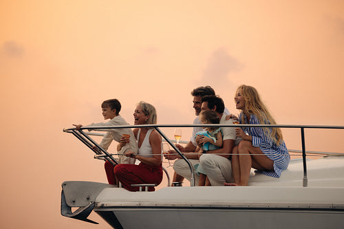 Happy family enjoying a vacation on a yacht at sunset, experiencing joy and togetherness