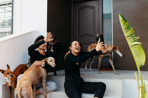 Two pet owners making a video call with their dogs
