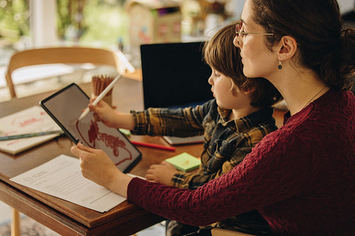 Mother and son drawing on digital tablet