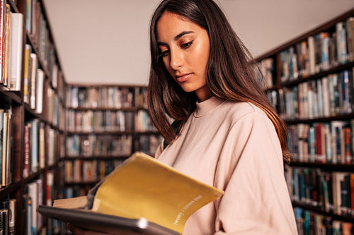 University student reading book in college library