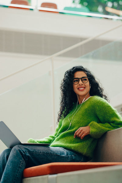 Research in the library keeps a student focused on her laptop and headphones