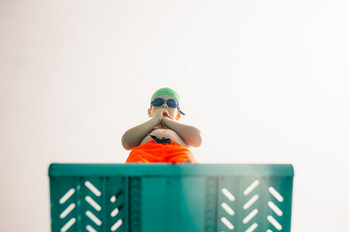 Boy on diving platform at pool