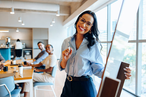 Smiling professional presenting at a meeting in an office environment