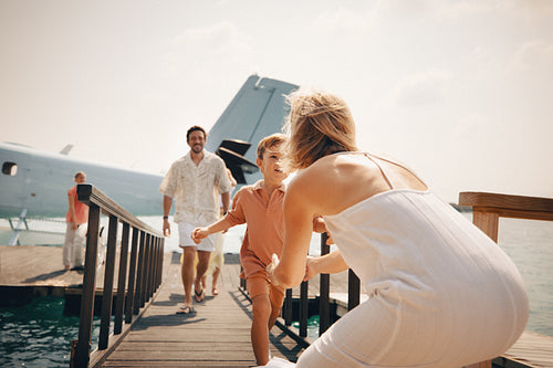 Excited boy greeting family after airplane arrival at tropical destination