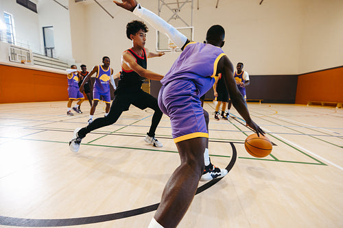 Basketball players competing during an intense game in a gymnasium