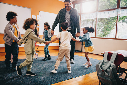 Elementary school fun. Teacher playing with his students in a classroom