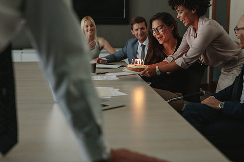 Coworkers celebrating birthday of a female colleague in office