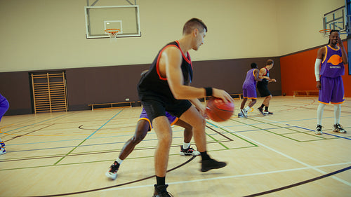 Men playing basketball on indoor court