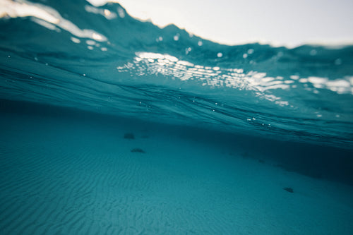 Underwater shot of blue ocean waves and seafloor