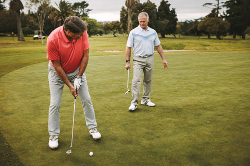 Senior golfer making a shot on putting green