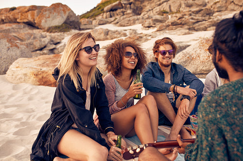 Friends enjoying a beach party with music and drinks