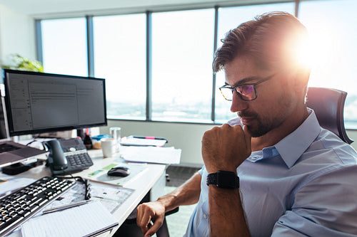 Business investor sitting at his desk in office.