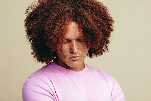 Man with red hair and freckles standing in a studio
