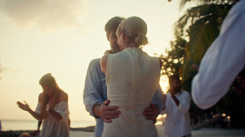 Magical moments in paradise: Couple dances on the beach at sunset with Bodu Beru performers and family during tropical island celebration