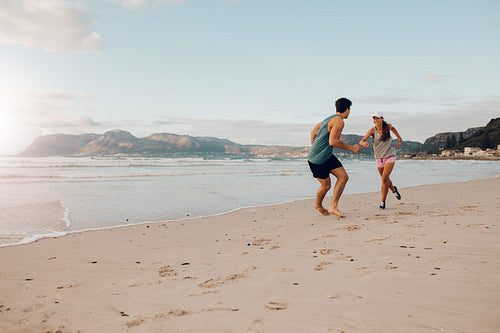 Fit young couple playing on the beach
