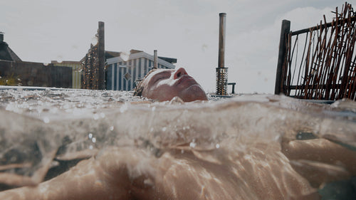 Underwater calm cold plunge as man recovers in an outdoor ice bath