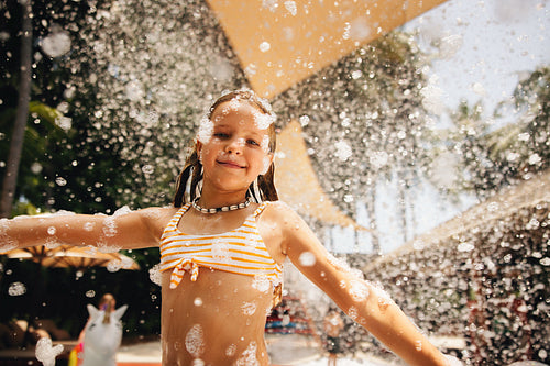 Joyful girl at a foam party during a tropical holiday