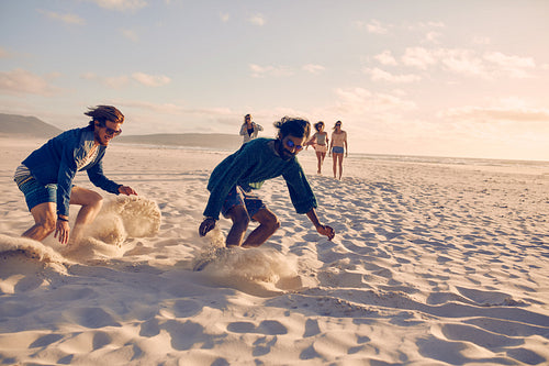 Young men running race on the beach