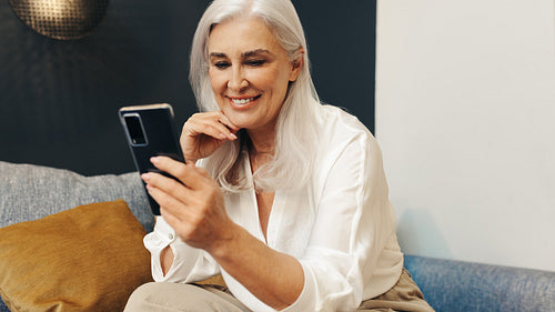 Senior woman enjoying browsing social media on her smartphone