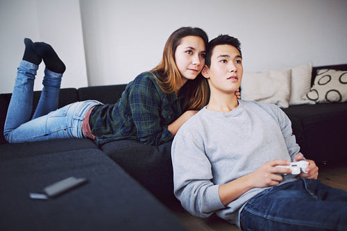 Young man playing video game with girlfriend - Indoors