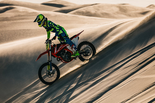 Motocross biker riding bike in the desert