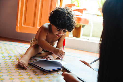Young Latin American child engaging in creative drawing activity at home