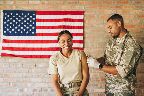 Cheerful female soldier smiling happily after vaccination