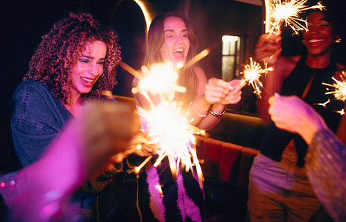 Group of friends celebrating with sparklers during a fun night out