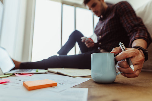 Man working on his laptop sitting at home with coffee