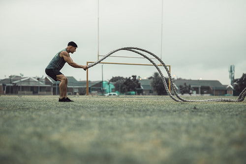 Athlete working out with battle ropes outdoors