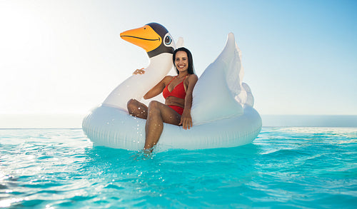 Woman on inflatable toy in swimming pool