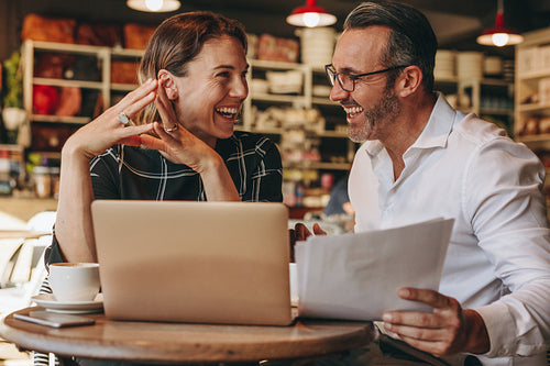 Smiling business people working at coffee shop