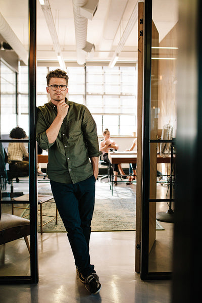 Handsome young man standing in office doorway