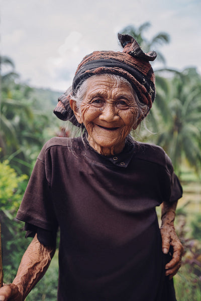 Old woman standing outdoors and smiling
