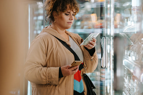 Customer reading product information at supermarket