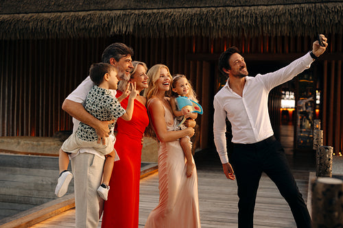 Elegant family capturing selfie before fine dining at luxury resort