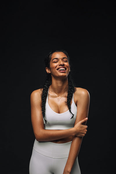 Laughing fit woman on black background