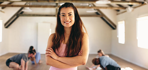Portrait of a woman smiling at the camera in a yoga class