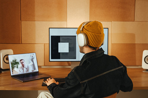 Man video calls a client at a creative desk setup