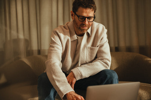 Focused business man works on a laptop in a remote work setup