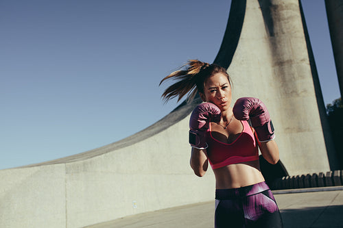 Young muscular woman practicing boxing