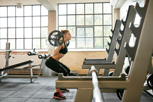 Fitness female doing squats in gym