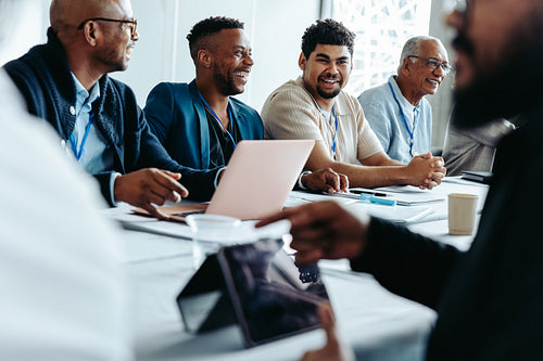 Businessmen in a meeting engaging in a friendly group conference at the office