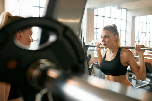 Young woman in gym doing squats