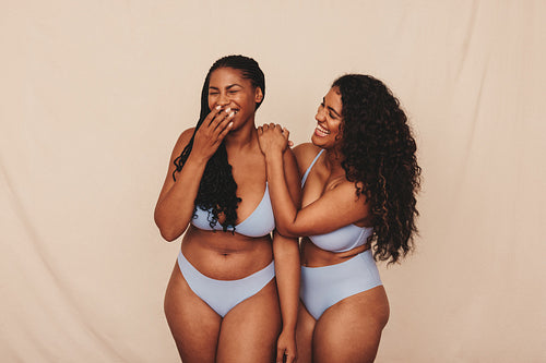 Cheerful young women laughing in blue underwear