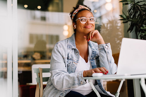 Professional woman working remotely in a cozy cafe