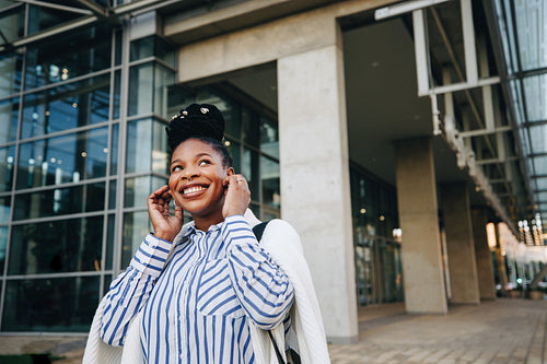 Smiling businesswoman listening to music during her morning commute
